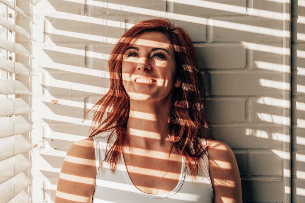 woman in white and brown stripe tank top
